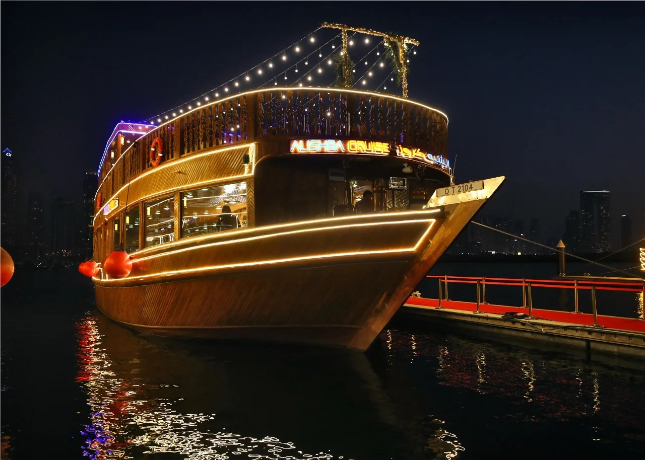 Dhow Cruise Dubai Marina boat lit up at night, docked at Dubai Marina