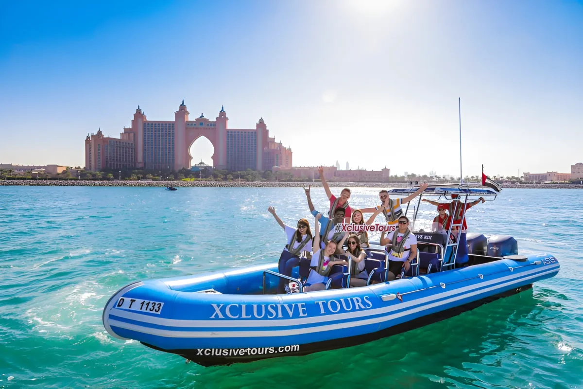 Guests cheering on a red Xclusive Tours speedboat with Atlantis The Palm in the background