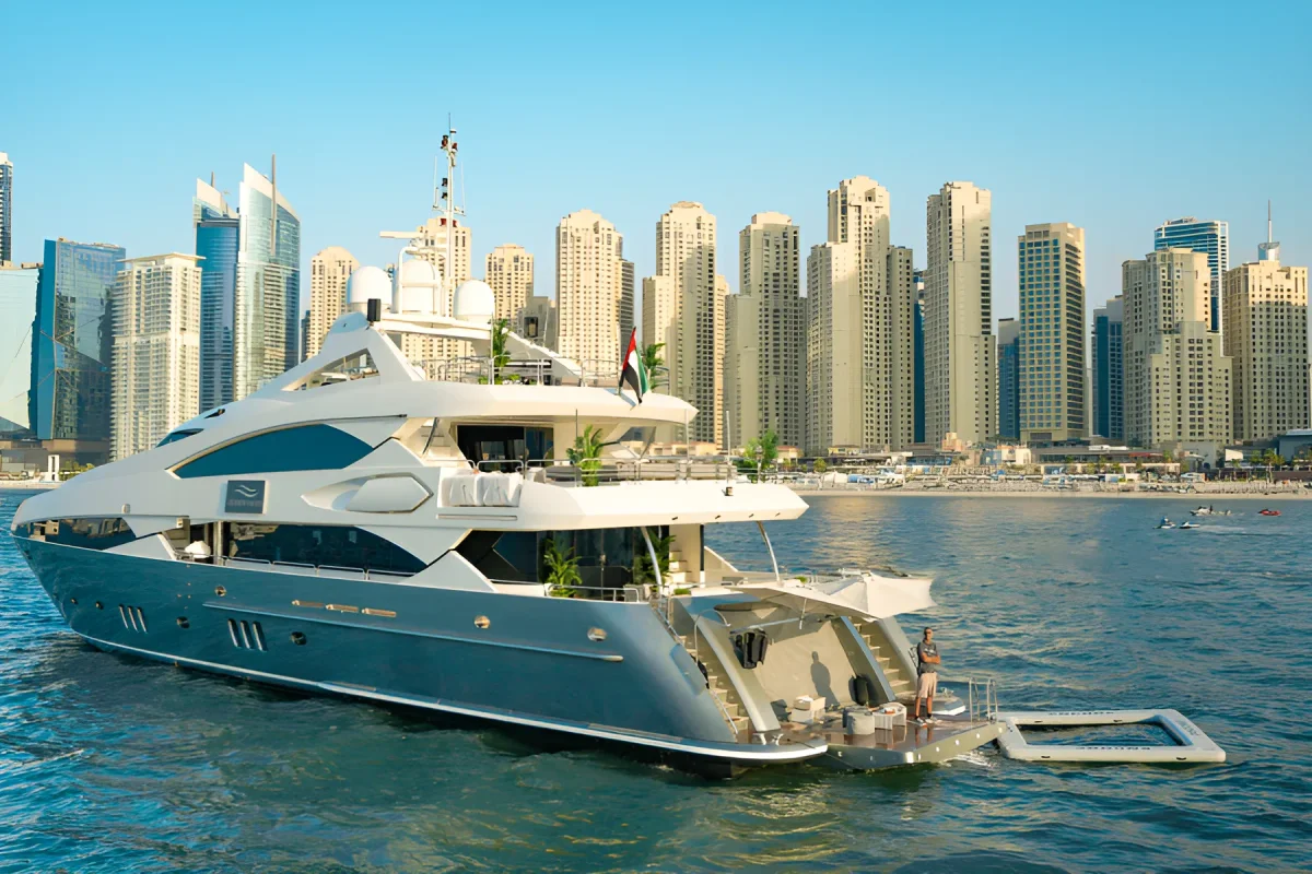 White and navy tri-deck Sunseeker superyacht anchored on Dubai Marina with its swim platform lowered